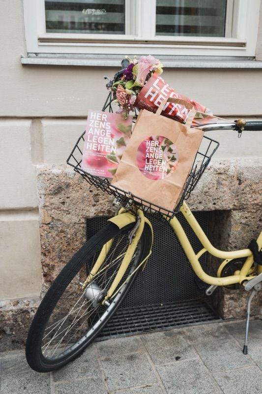 Fahrrad mit Blumen und der Tasche „Herzensangelegenheiten“ im Korb